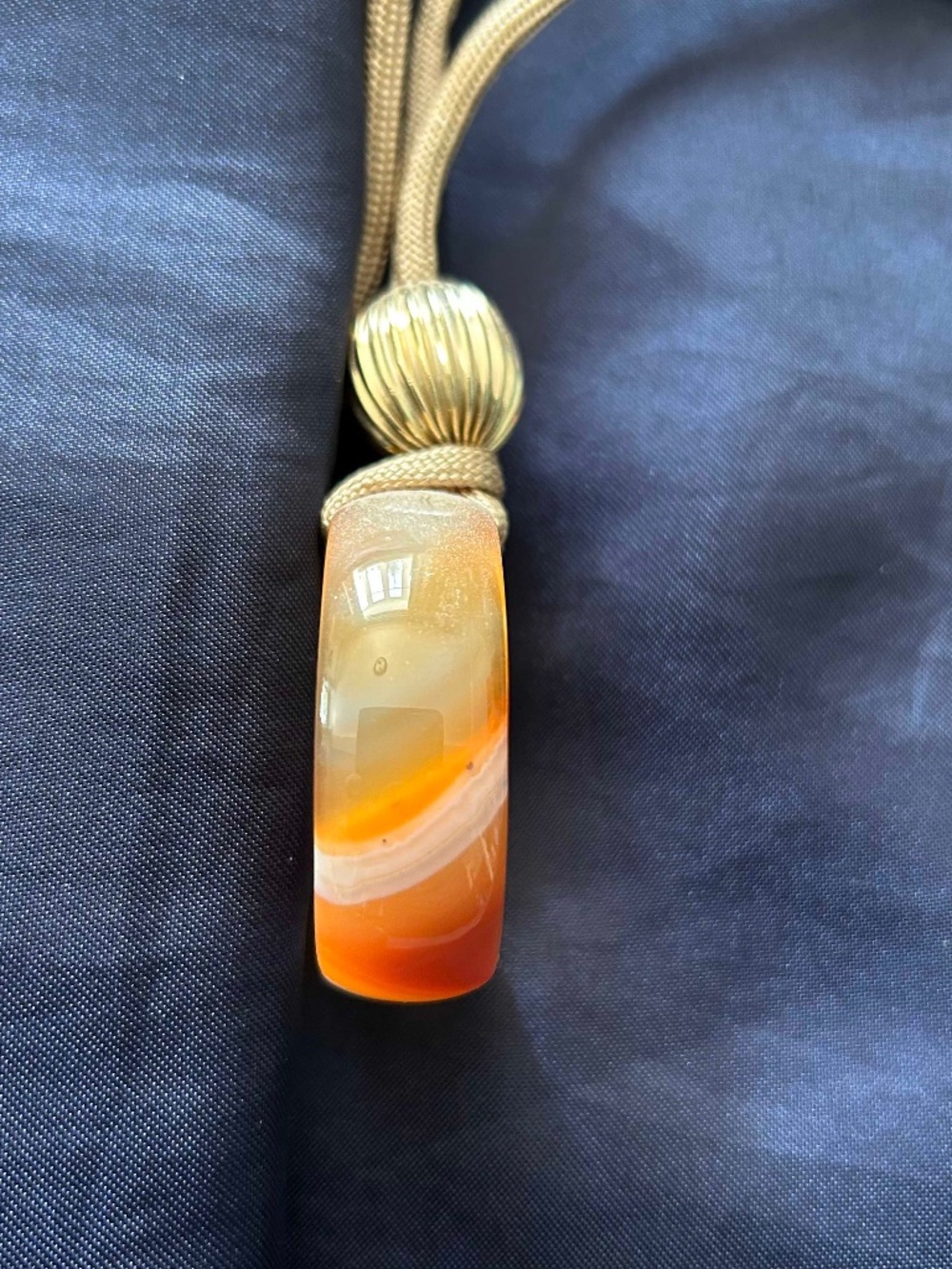 NECKLACE GLASS DONUT ORANGE/TAN WITH GOLD TONE BEAD ON WIDE SILK CORD, 18 INCHES